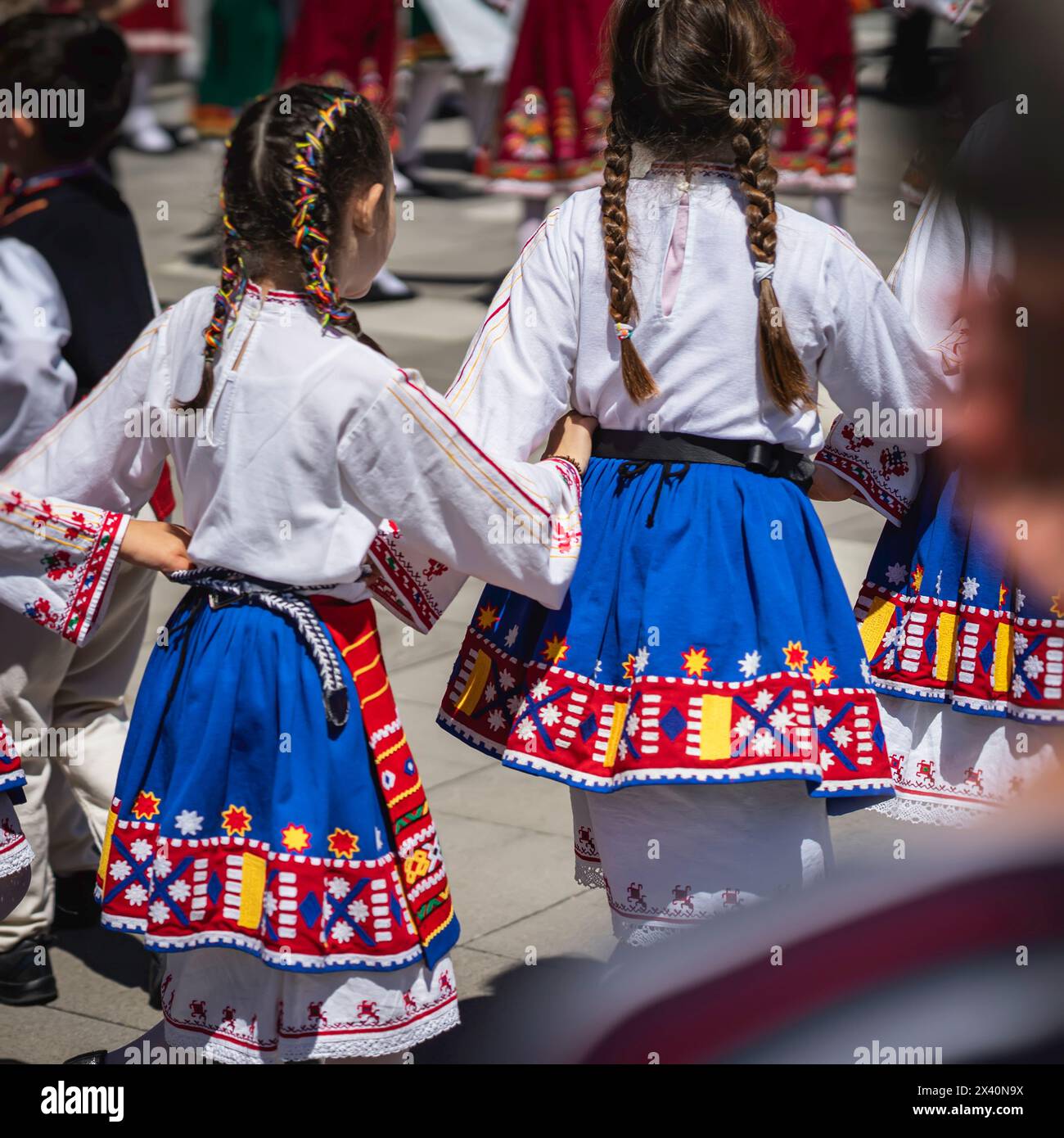Little girls dancing folk dance outdoors in summer. Bulgarian ethnic art Stock Photo