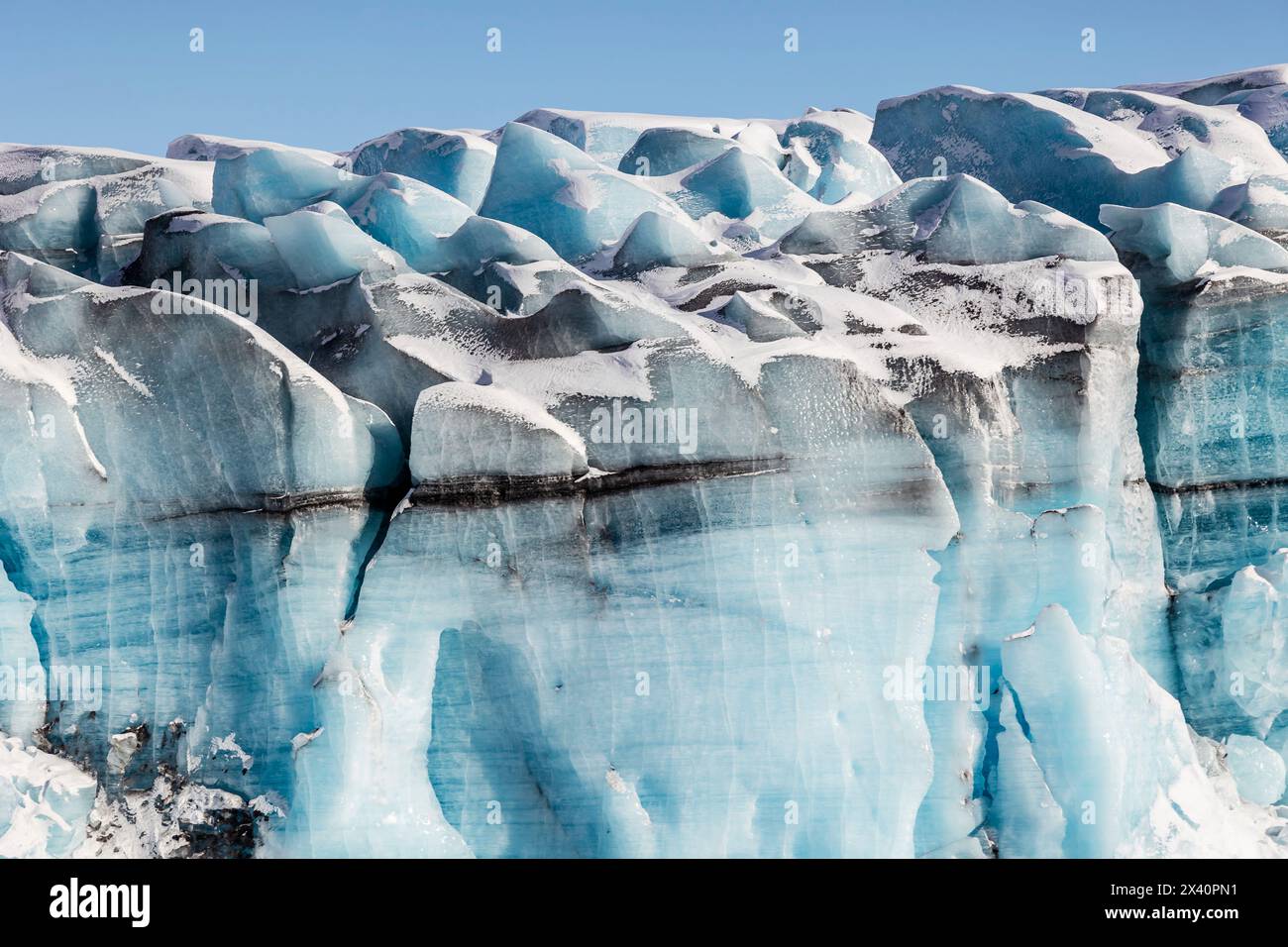 Blue ice formations on Knik glacier against a bright blue sky; Alaska, United States of America Stock Photo