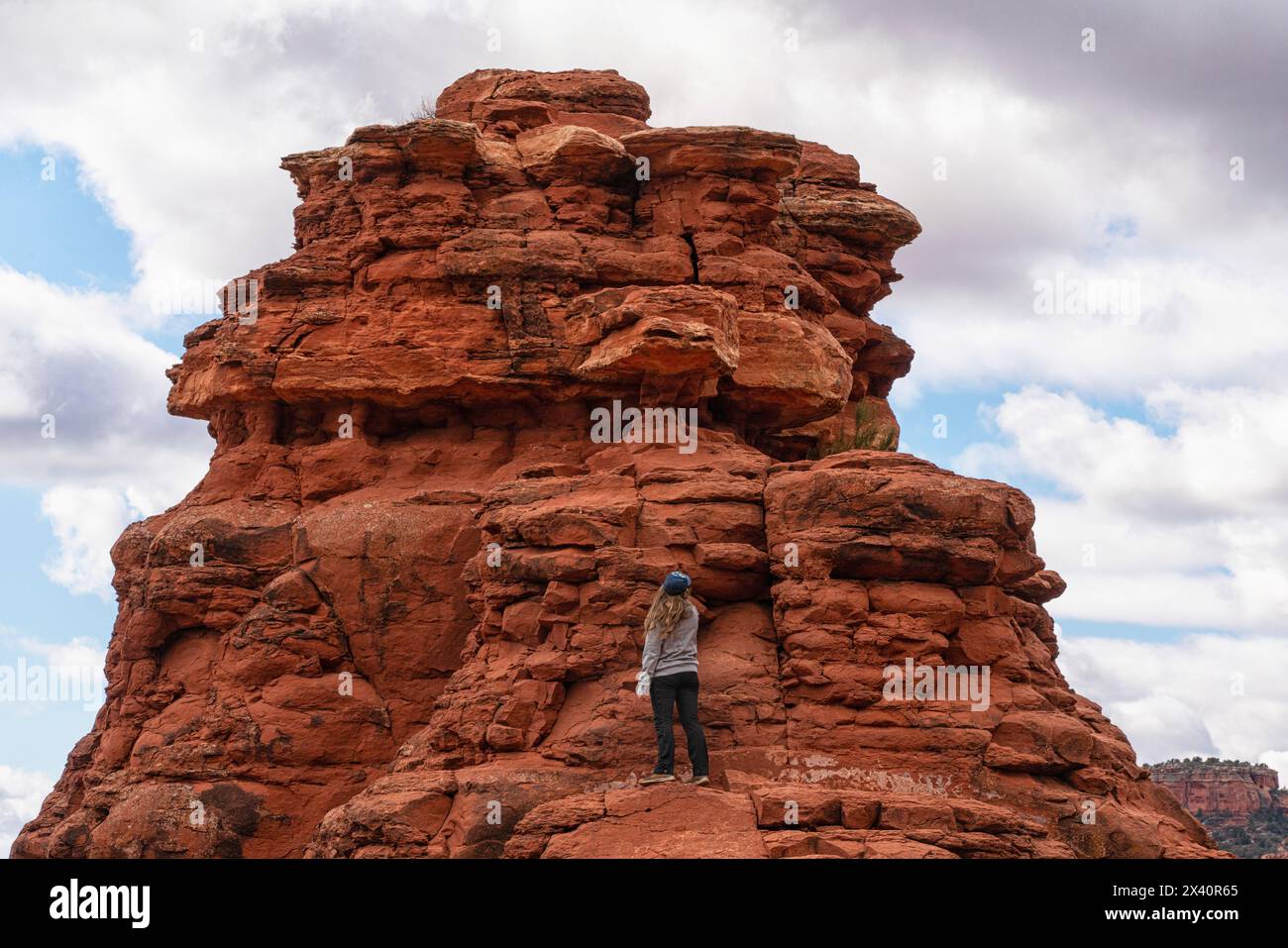 Woman standing at one of Sedona's vortexes, an area of earth energy; Sedona, Arizona, United States of America Stock Photo