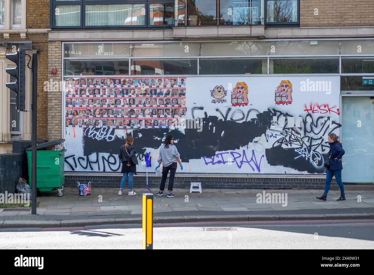 LONDON- MARCH, 30, 2024: Finchley Road, North West London- people putting up portrait posters of Isreal hostages taken by Hamas on October 7th. Stock Photo
