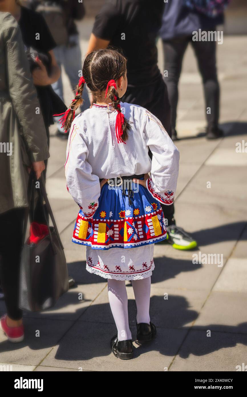 Girl in traditional national Bulgarian costume at a folklore festival, rear view Stock Photo