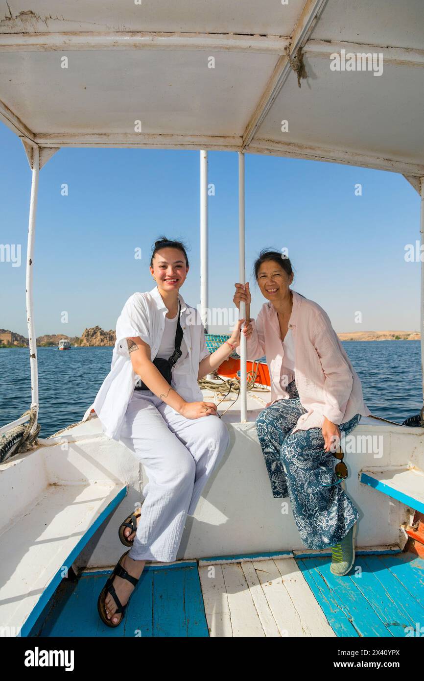 Female tourists enjoy a boat cruise on the river Nile to Philae Temple near Aswan in Egypt; Egypt Stock Photo