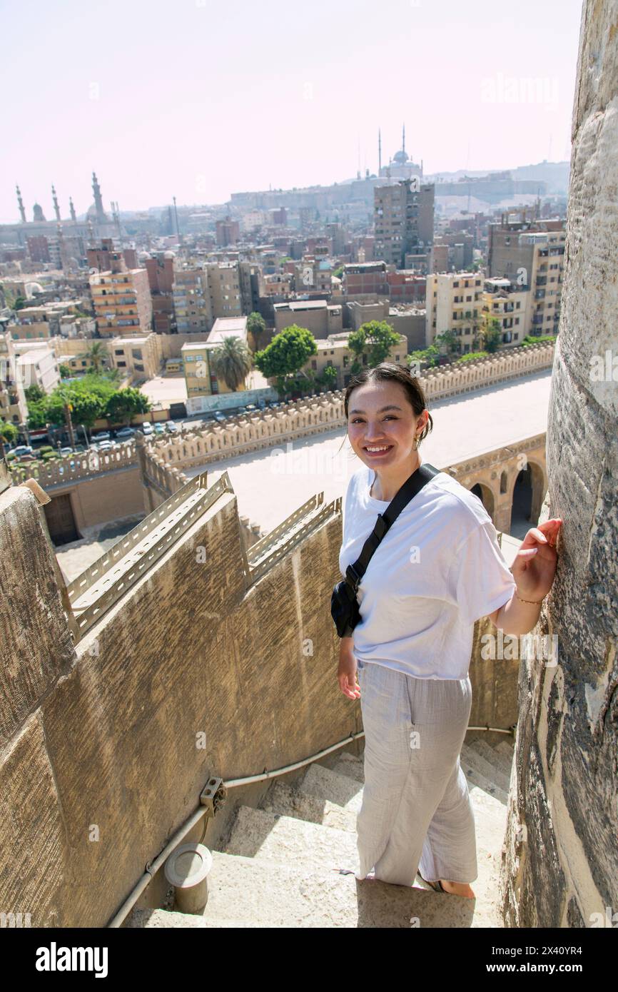 Young female tourist ascending the minaret at the Mosque of Ibn Tulun, the largest in Cairo, Egypt and one of the oldest; Cairo, Egypt Stock Photo