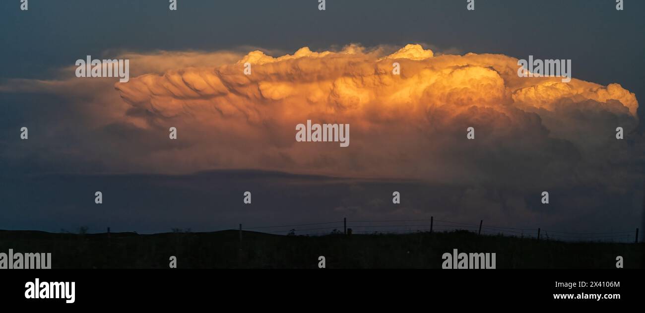 Panoramic image of a sunlit supercell. A large anvil is present in what is a dramatic example of a supercell thunderstorm.. Stock Photo