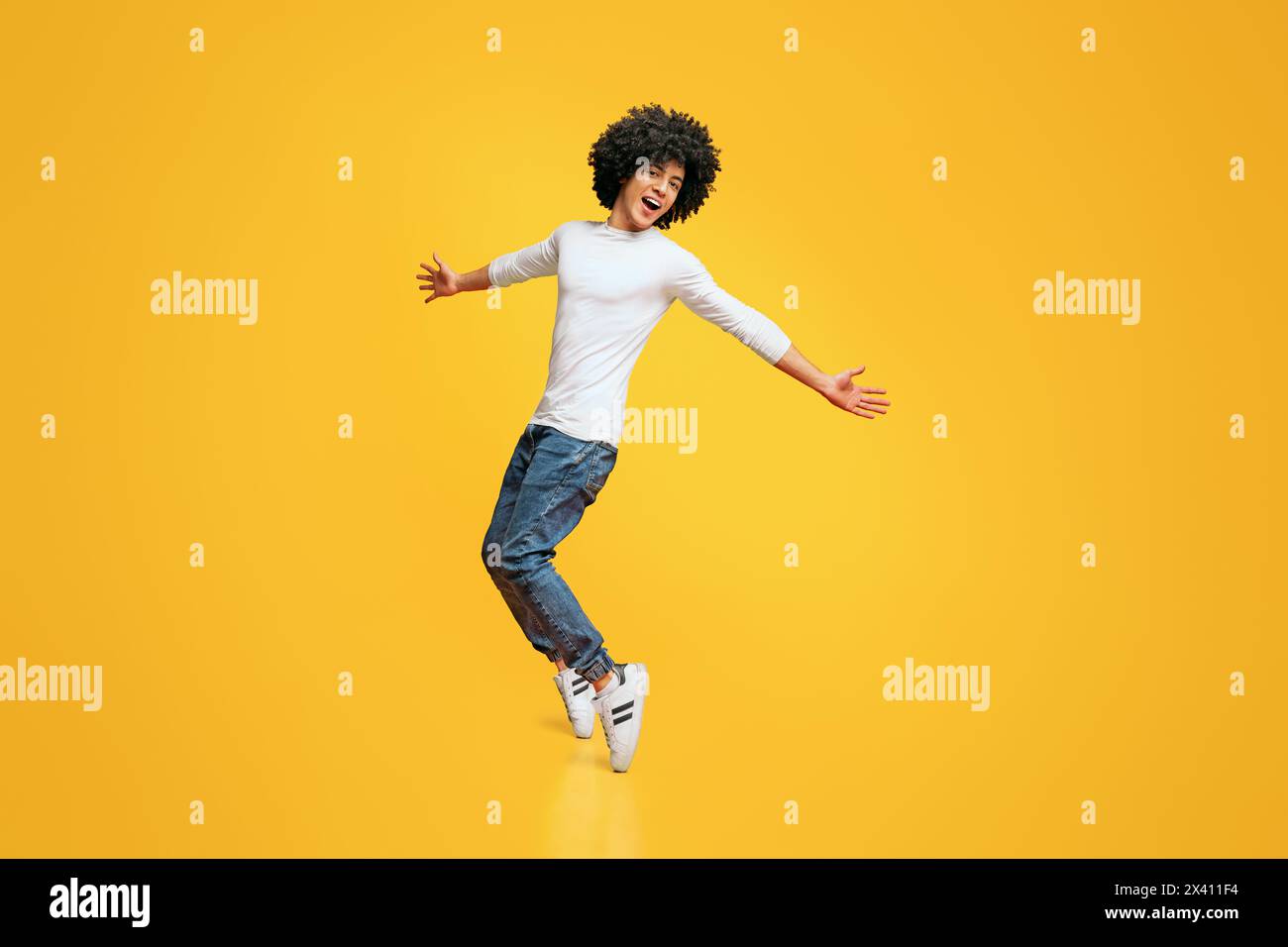 Young funny african-american man standing on his tiptoes Stock Photo