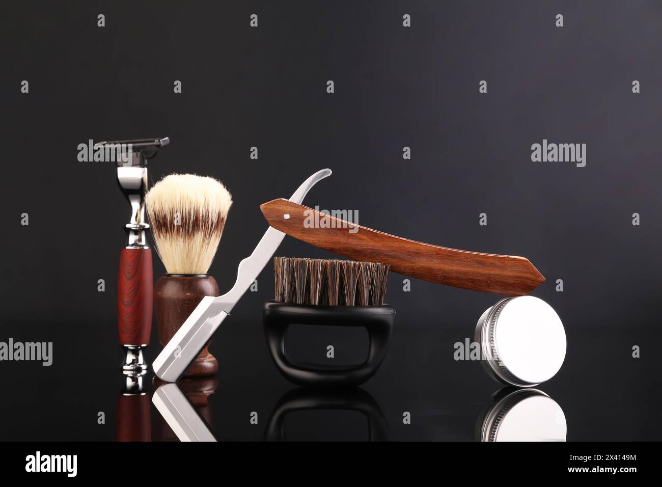 Moustache and beard styling tools on black mirror surface Stock Photo