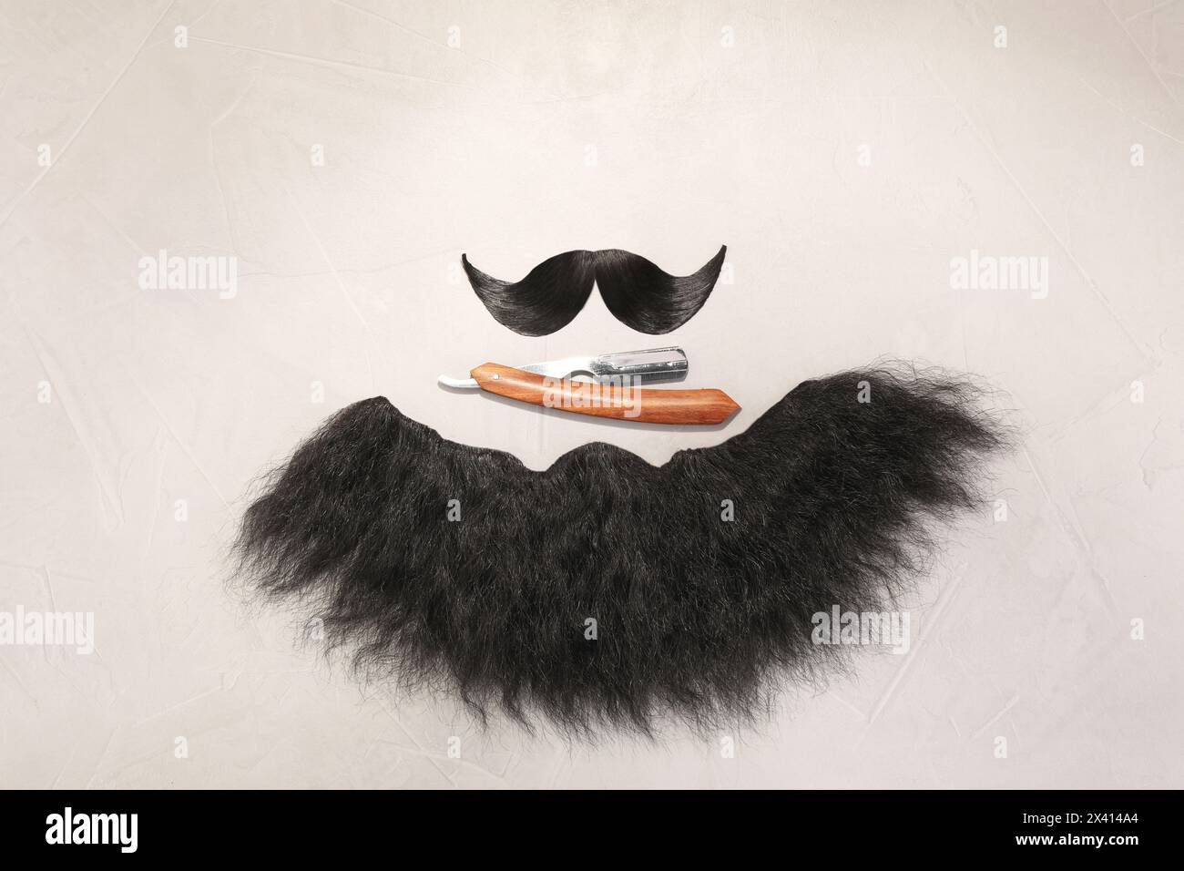 Artificial moustache, beard and straight razor on light background, flat lay Stock Photo