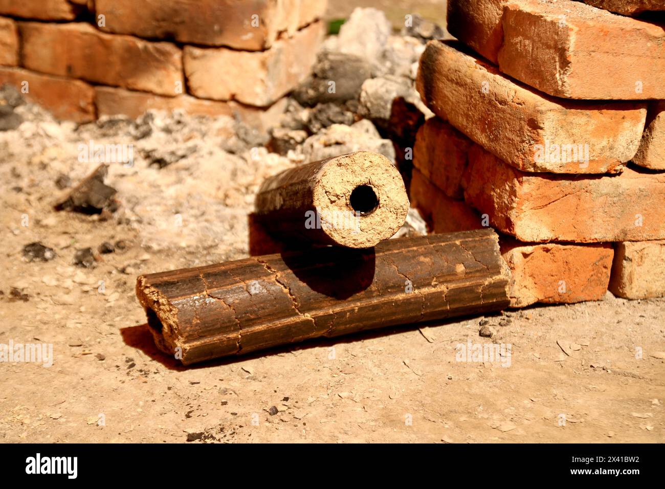 Charcoals, renewable solid fuel made from rice husk. cooking in a village party on a temporary brick made oven with Rice Husk Briquette fuel. Agro-res Stock Photo