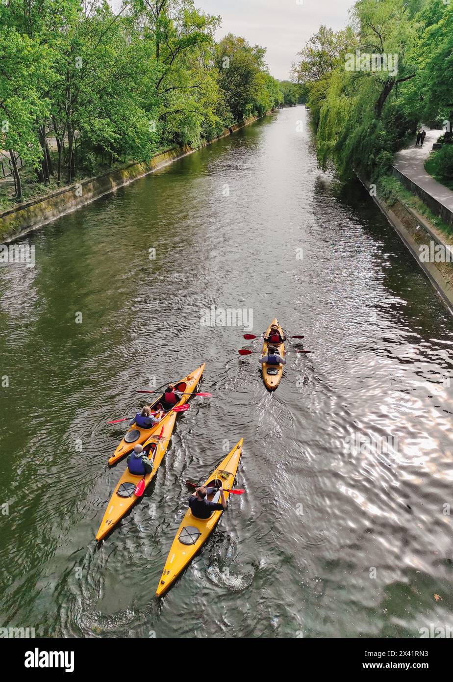 Group of kayak rowers swim in the Landwehr Canal (German: Landwehrkanal) in Kreuzberg district of Berlin, Germany Stock Photo