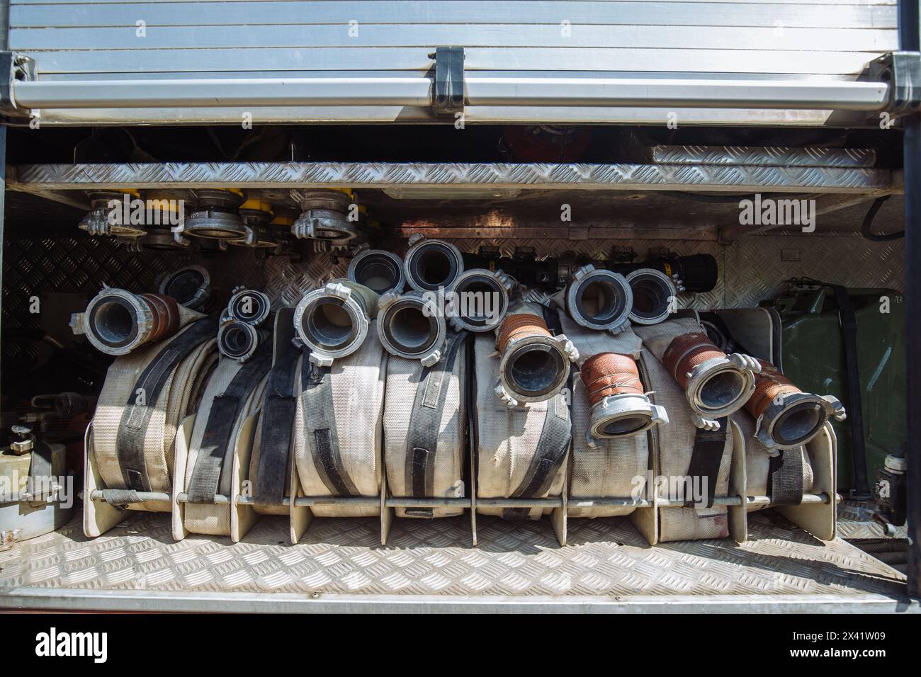 Rolled fire hoses in firetruck. Stock Photo