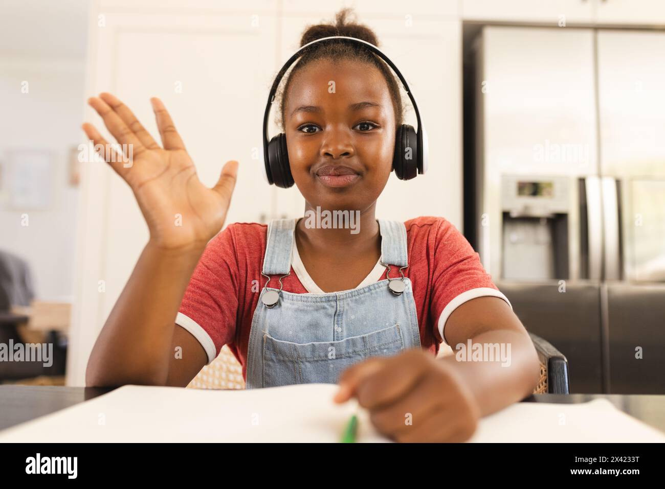 African American girl in headphones, waving on video call at home ...