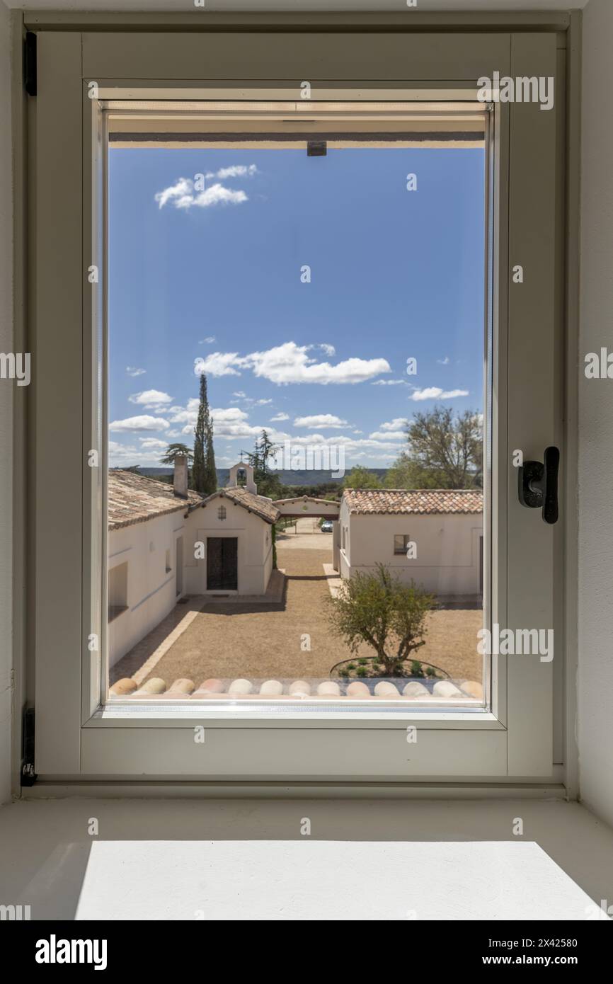 a window looking out onto a country house with its own catholic chapel Stock Photo