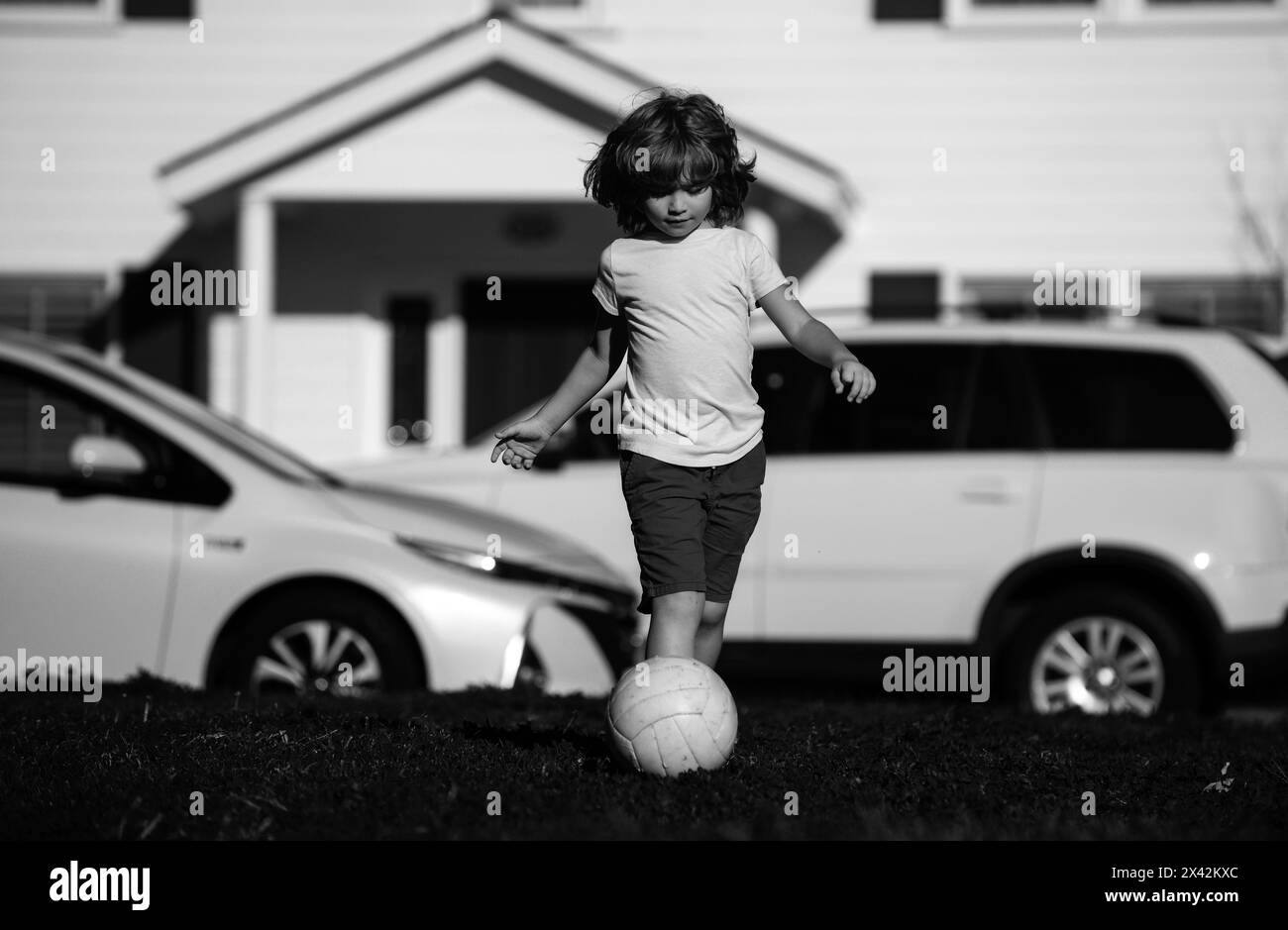 Boy football player kicking football on the sports field. Active kids ...