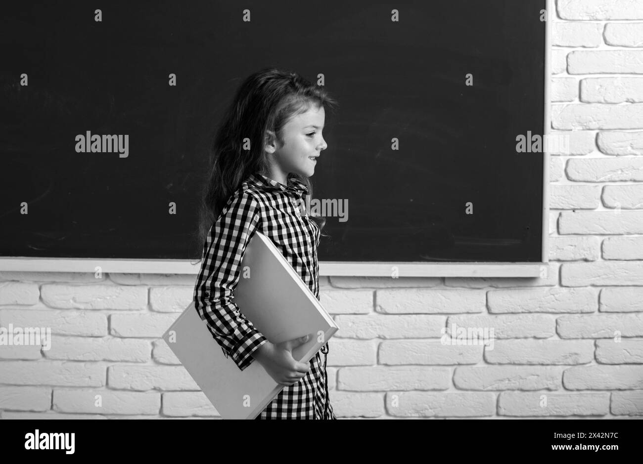 Cute child at school. Kid is learning in class on background of ...