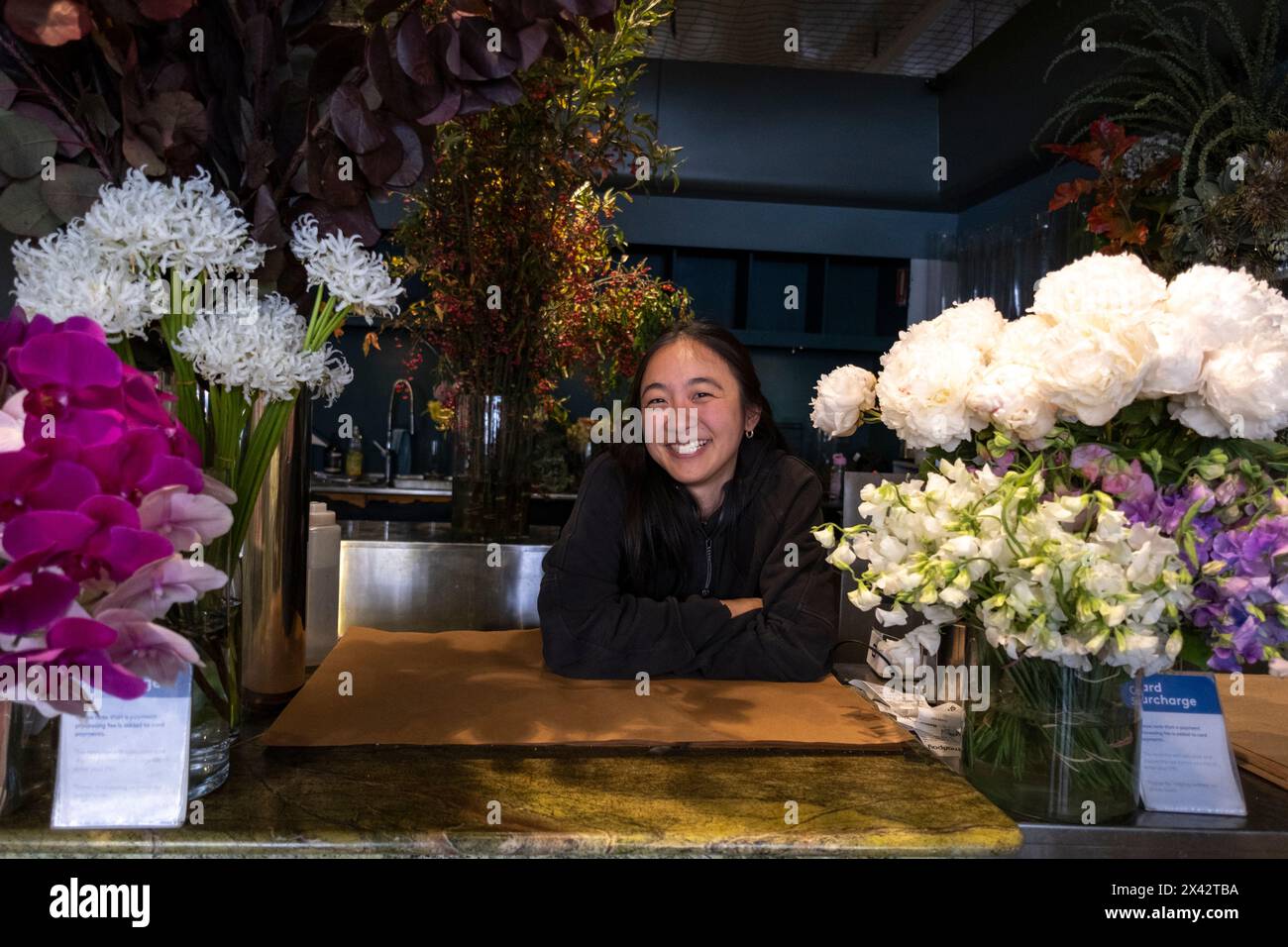 A woman selling flowers at a stall in the South Melbourne market. South