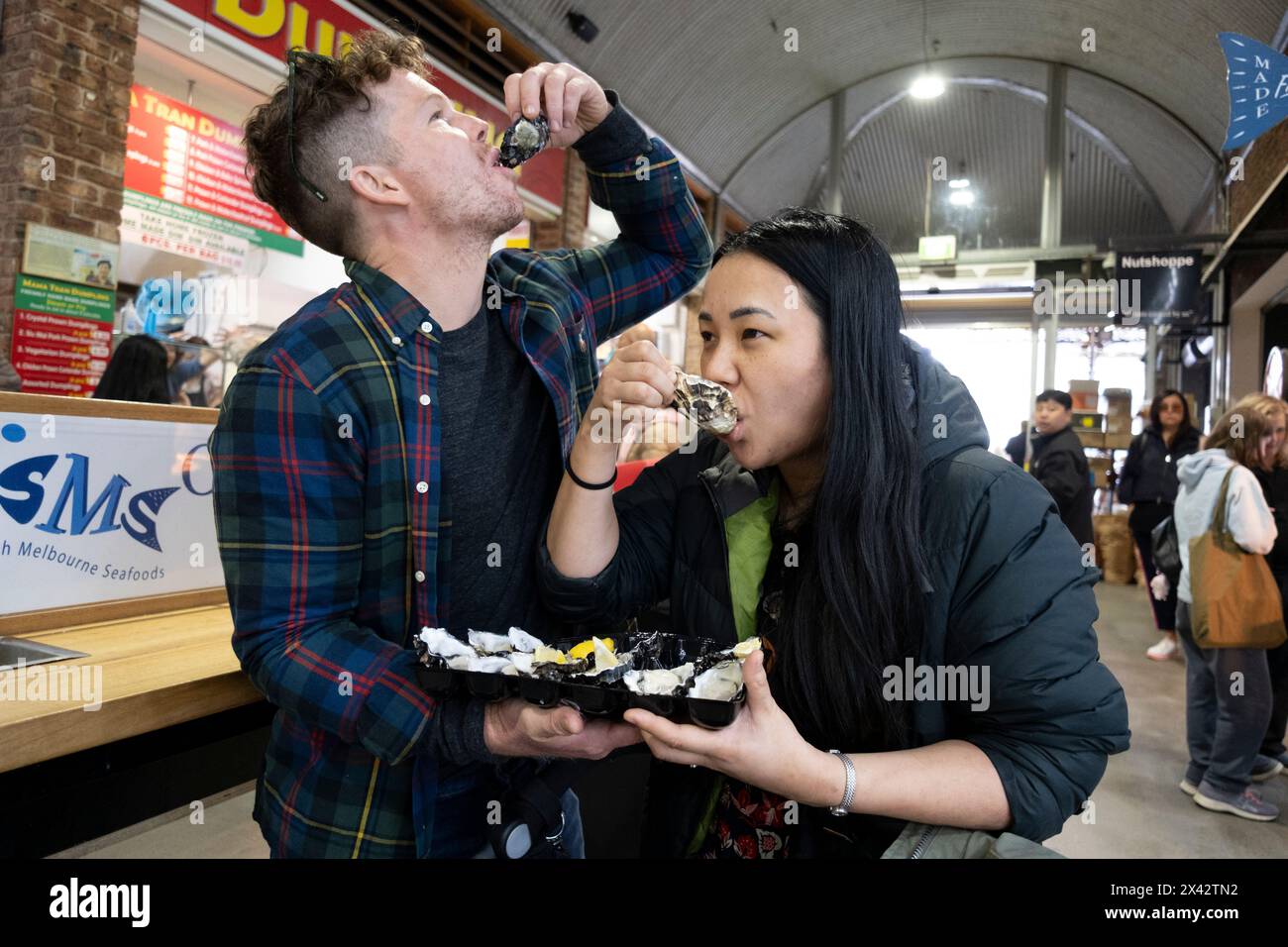 Customers eat oysters in the food hall of the South Melbourne market. South Melbourne, Victoria, Australia. Stock Photo