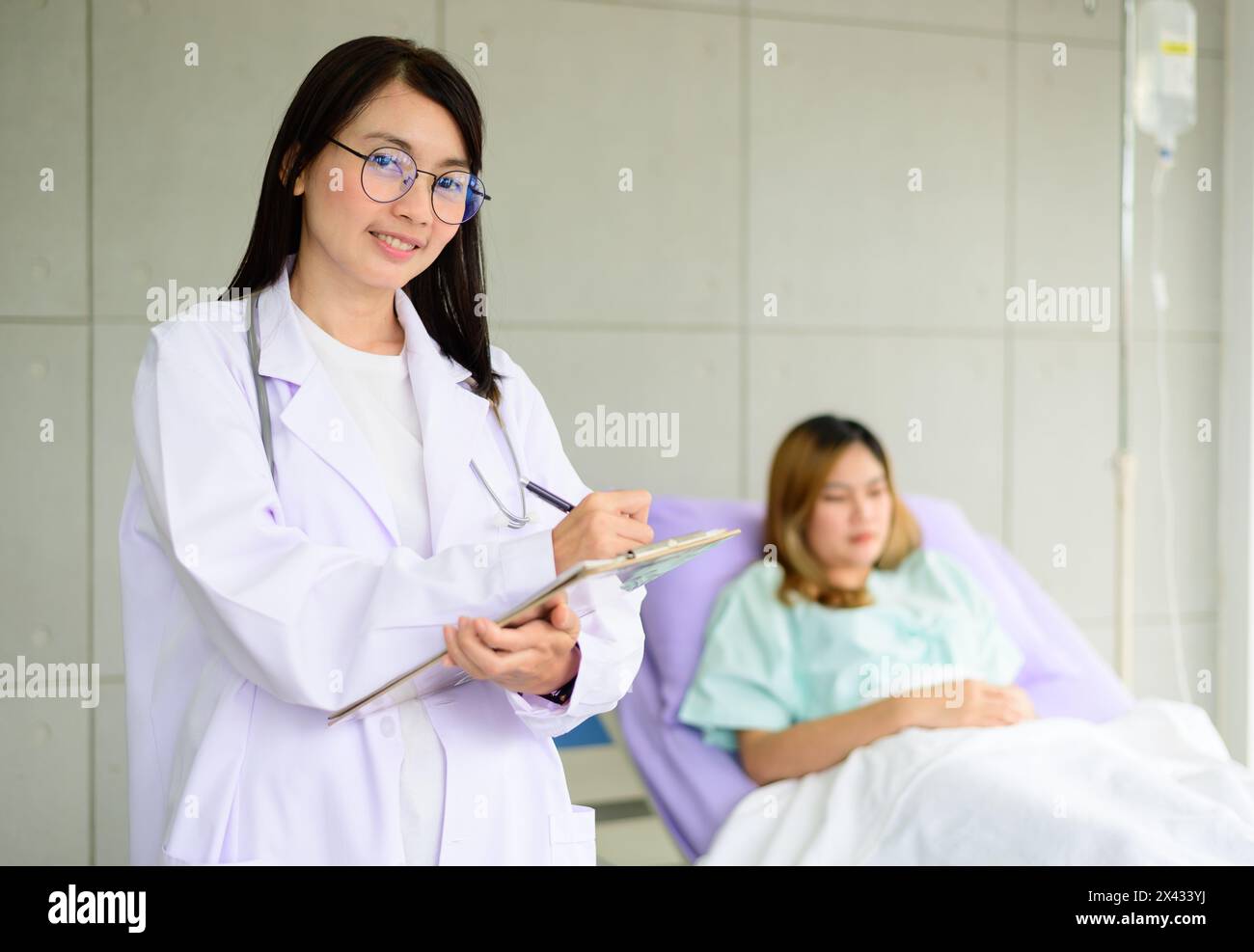 Asian female doctor hand taking note information of patient lying on bed Stock Photo