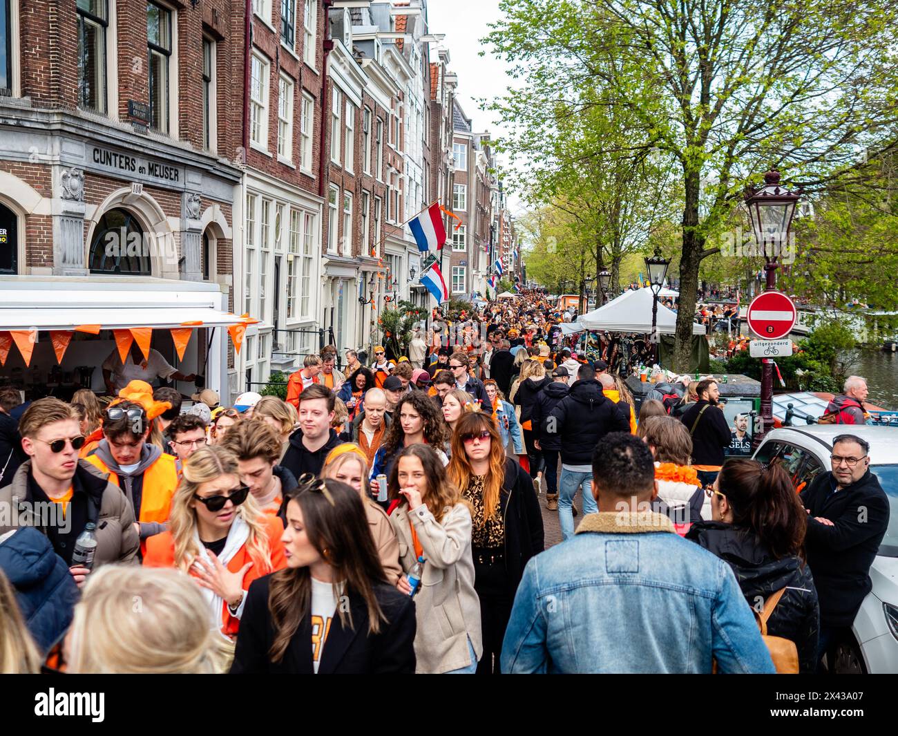 April 27th, Amsterdam. King's Day is renowned for being one of the biggest and most colorful festivities in the country, especially in Amsterdam. The city is bursting with orange as people enjoy the biggest street party of the year, enjoying the free markets and having fun on the boats along the canals. Stock Photo