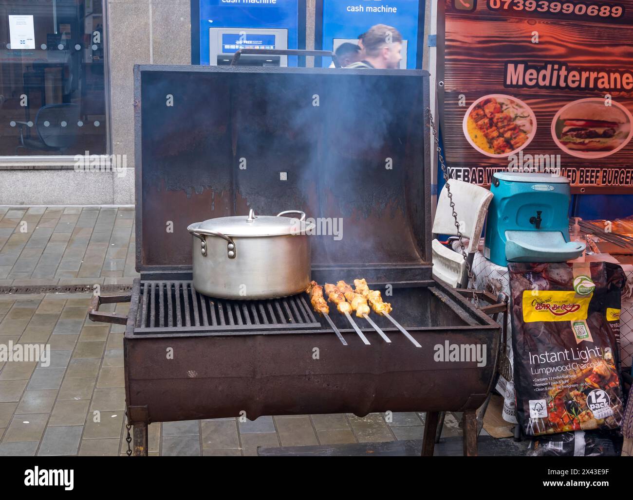 Cooking pot and four kebabs on trough barbeque, Lincoln City, Lincolnshire, England, UK Stock Photo