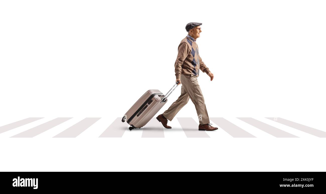 Full length profile shot of an elderly man pulling a suitcase and walking on a street isolated on white background Stock Photo