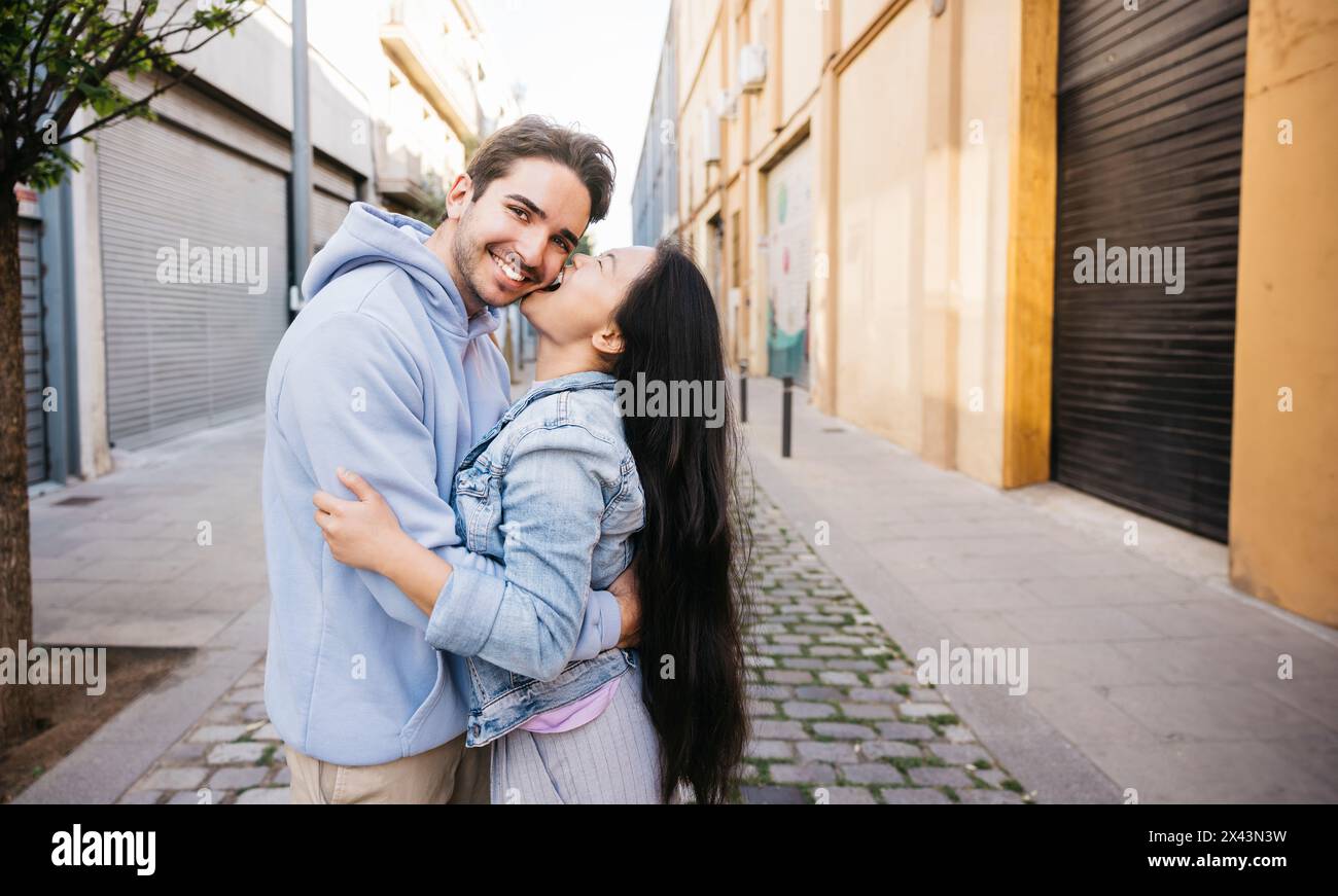Portrait of an interracial playful couple embracing while standing outdoors. Couple enjoying themselves outdoors. Stock Photo