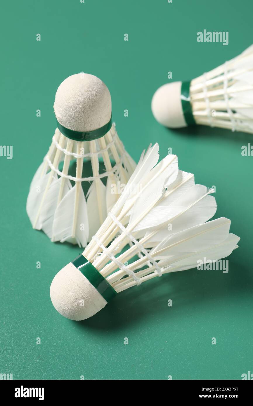 Feather badminton shuttlecocks on green background, closeup Stock Photo