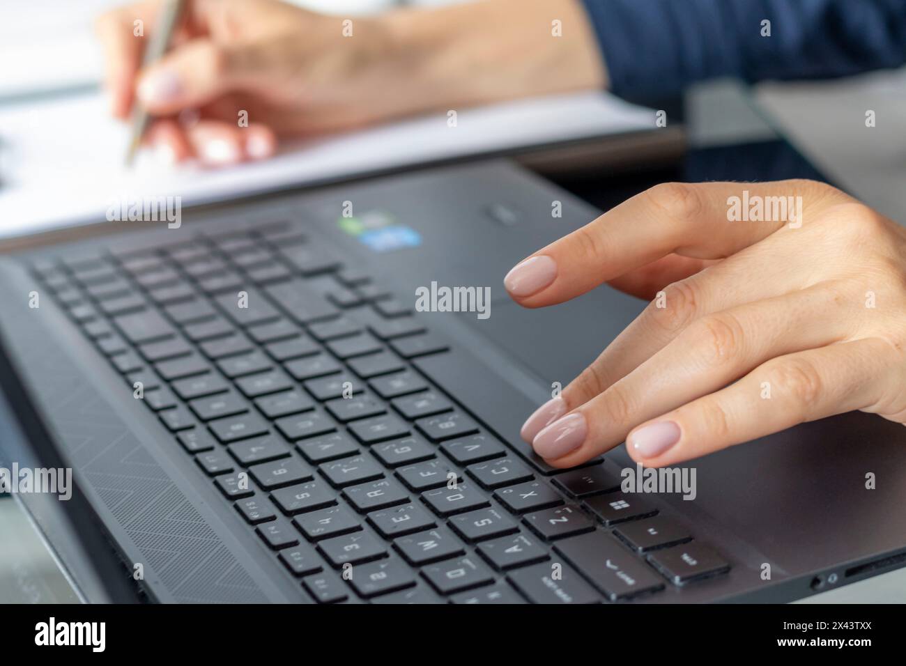 Close up shot of the woman with beautiful hands in the business attire, working on the laptop in the office, making notes Stock Photo