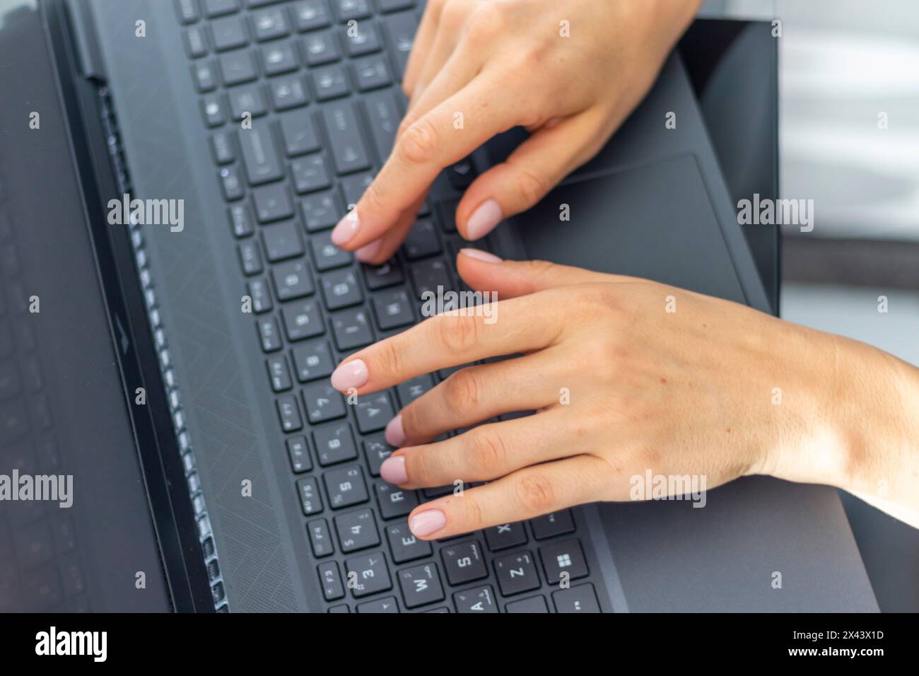 Close up shot of the woman with beautiful hands in the business attire, working on the laptop in the office Stock Photo