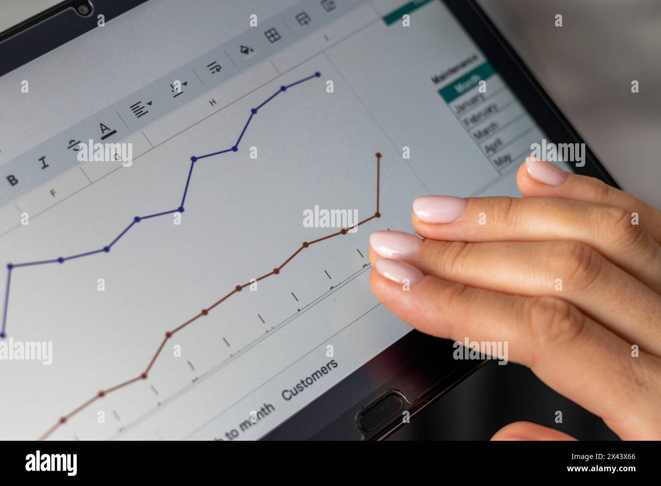 Close up shot of the woman with beautiful hands , using tablet, studying mortgage sales report Stock Photo