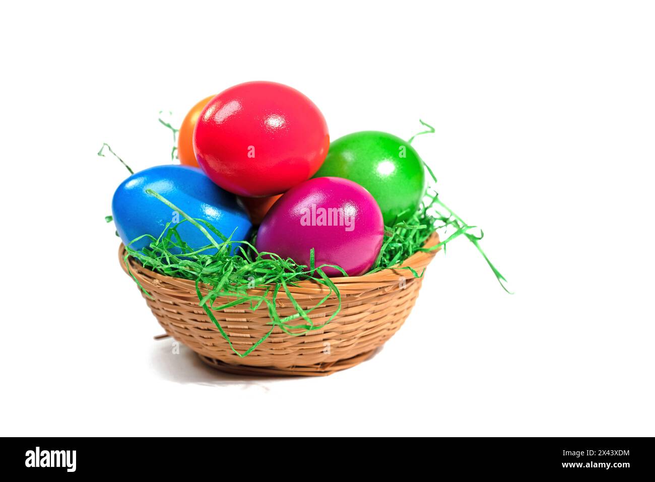 Colorful Easter eggs in a basket against a white background Stock Photo