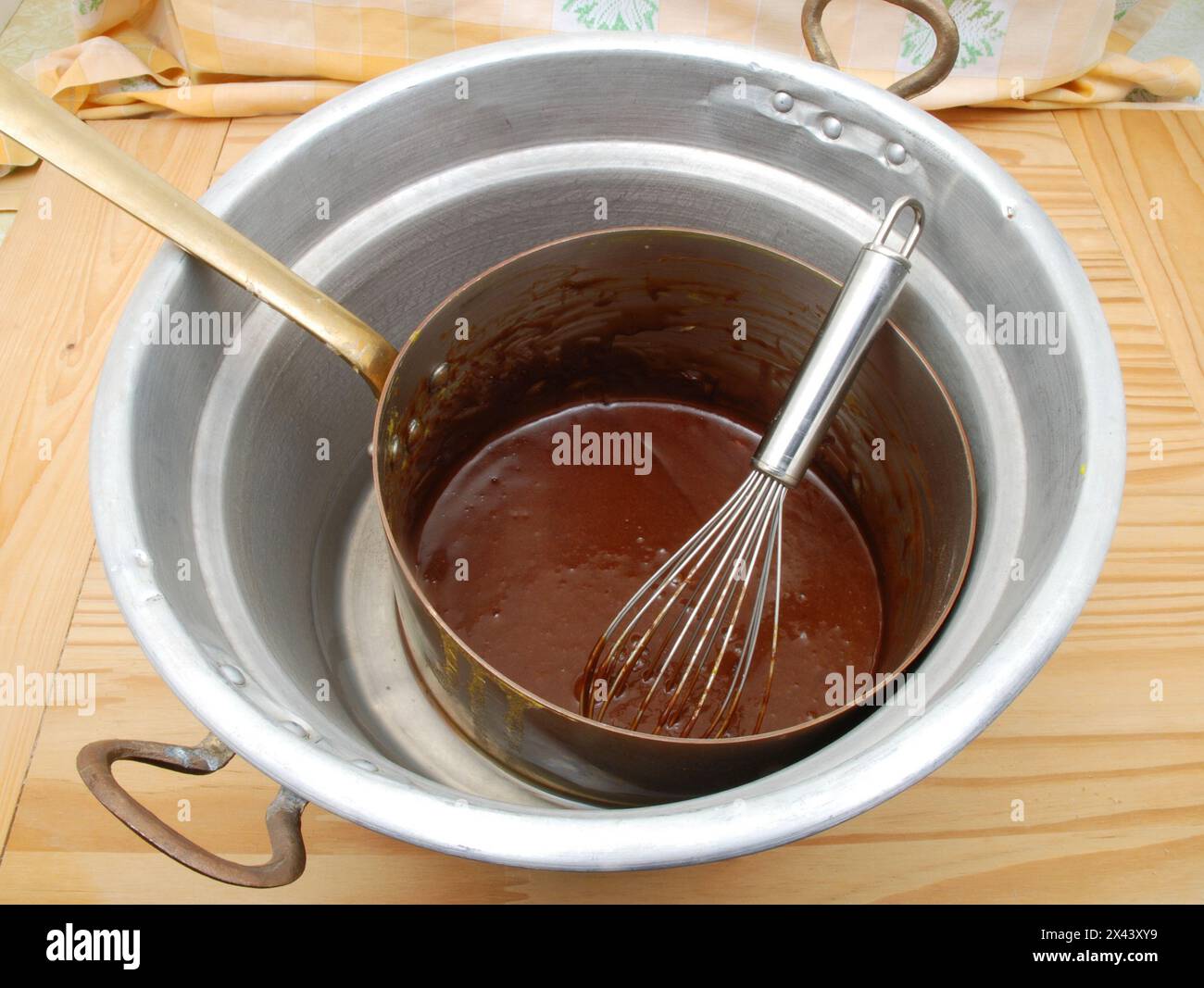 Melted chocolate in a double boiler in copper pot. Stock Photo