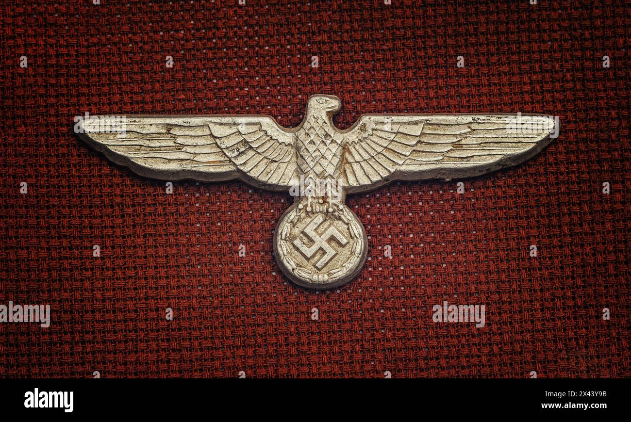 World War Two German nazi hat badge on dark red background Stock Photo