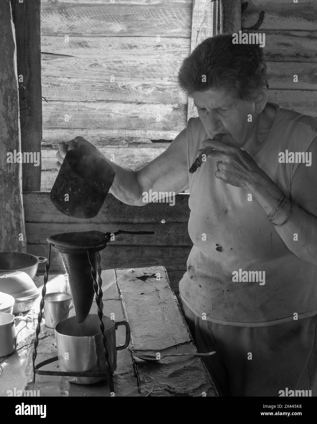 An infrared picture of a coffee farmers wife in the farmhouse smoking a
