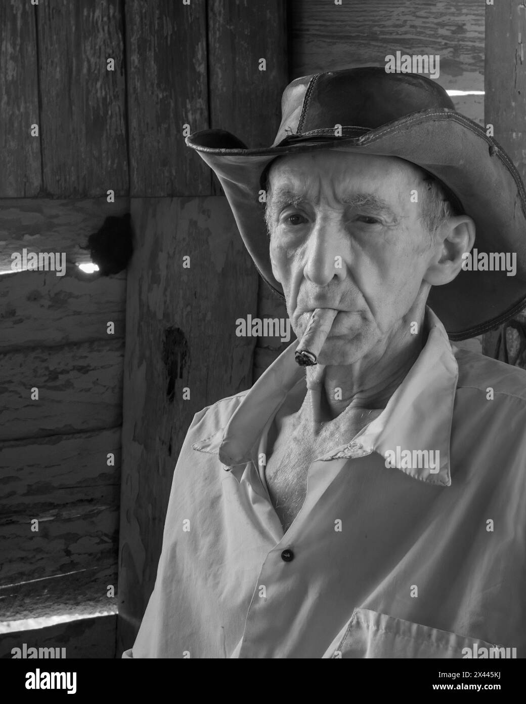 An infrared picture of a coffee farmer smoking a cigar in his farmhouse