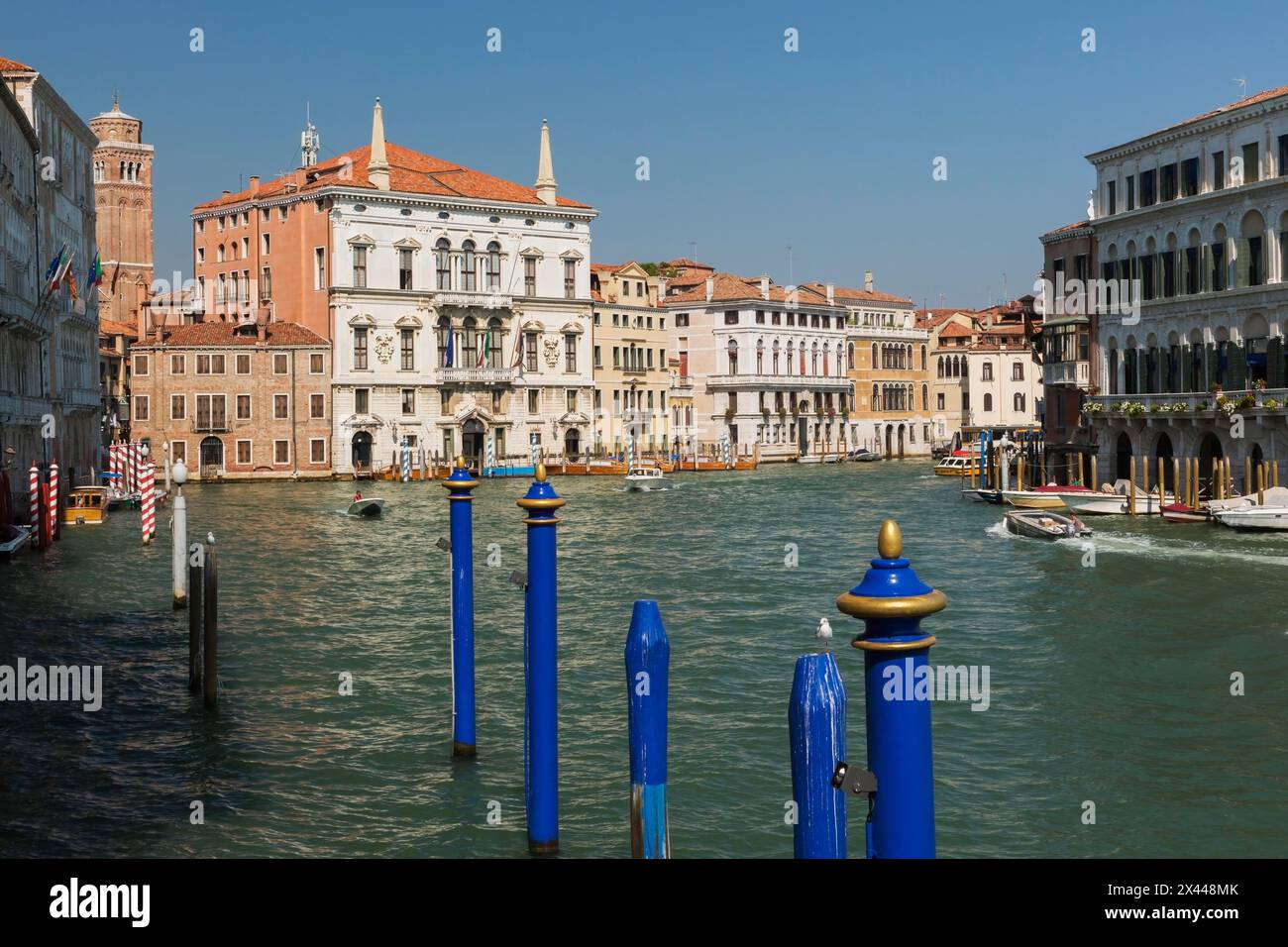 Blue mooring posts and water taxis on Grand canal with Renaissance architectural style residential palace buildings, San Polo district, Venice Stock Photo
