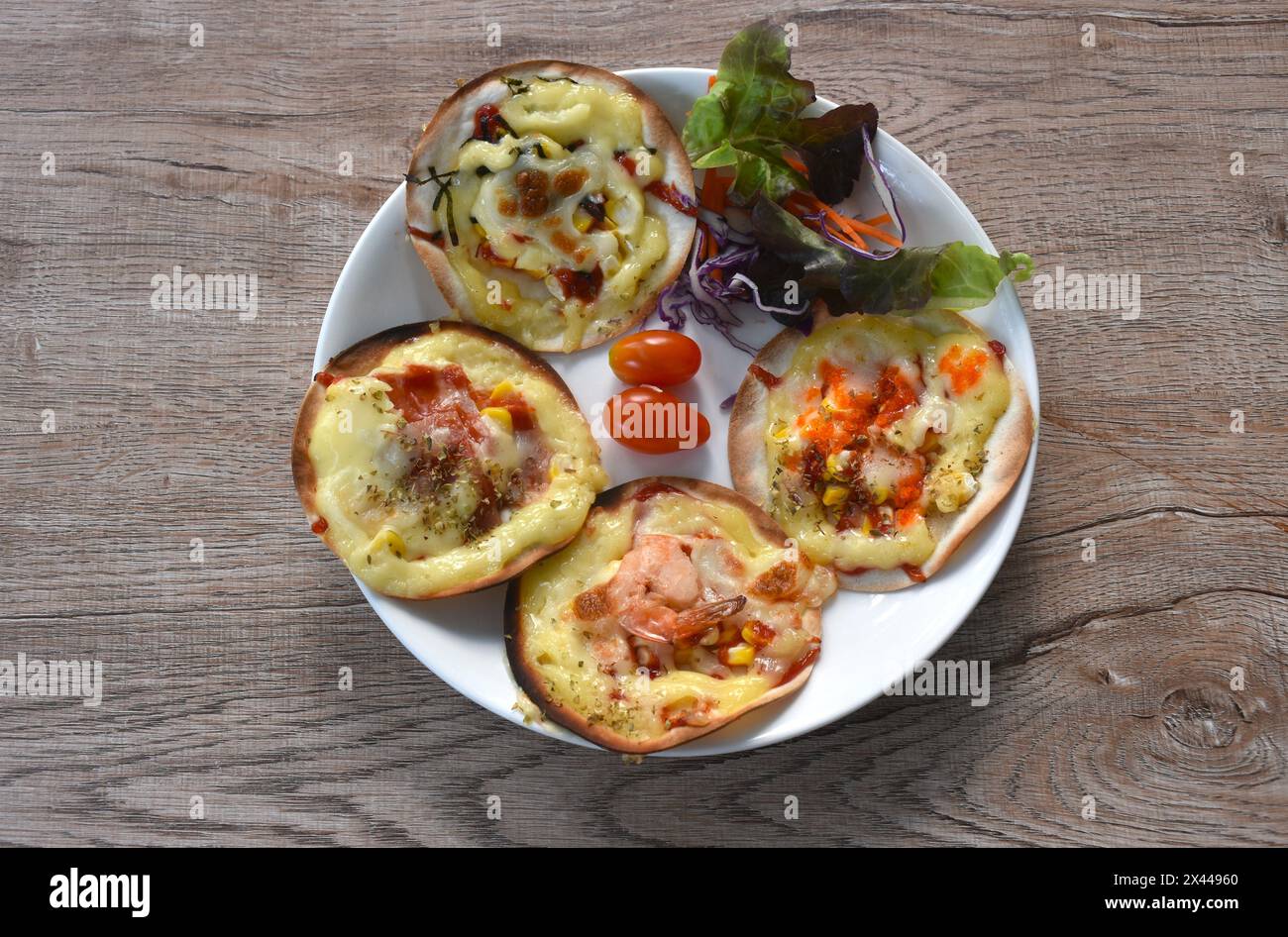 mini homemade pizza topping sausage and cheese with salad on plate Stock Photo