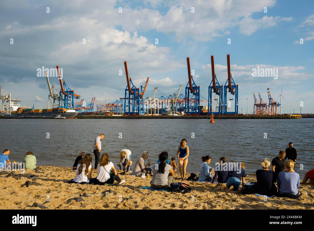 People on the beach, Strandbar Strandperle, Elbe beach, Hamburg harbour in the background, Oevelgoenne, Hamburg, Germany Stock Photo
