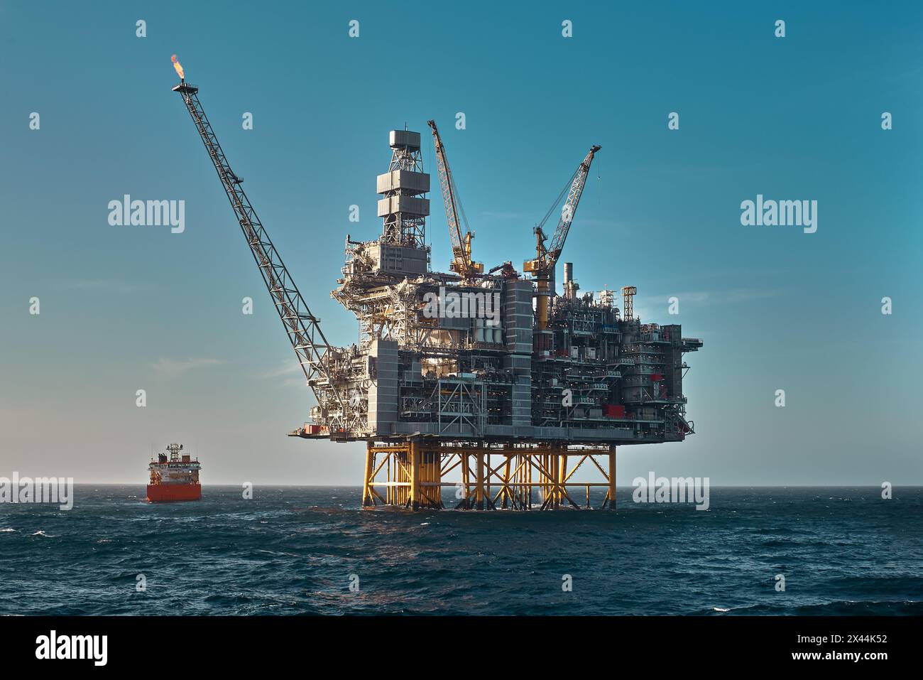 Jack up drilling rig and supply vessel in the sea with minimum colours ...
