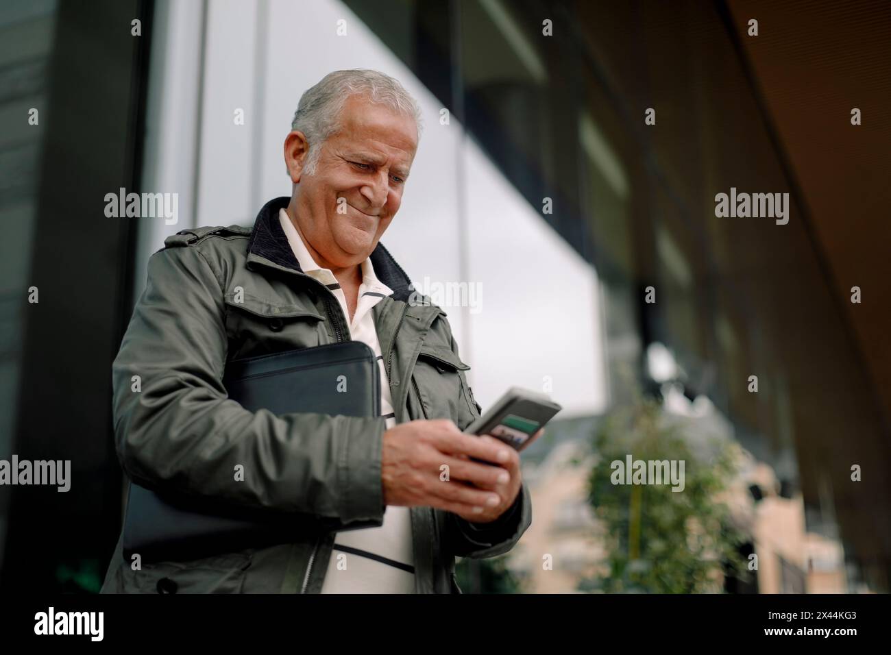 Smiling retired senior man using smart phone Stock Photo