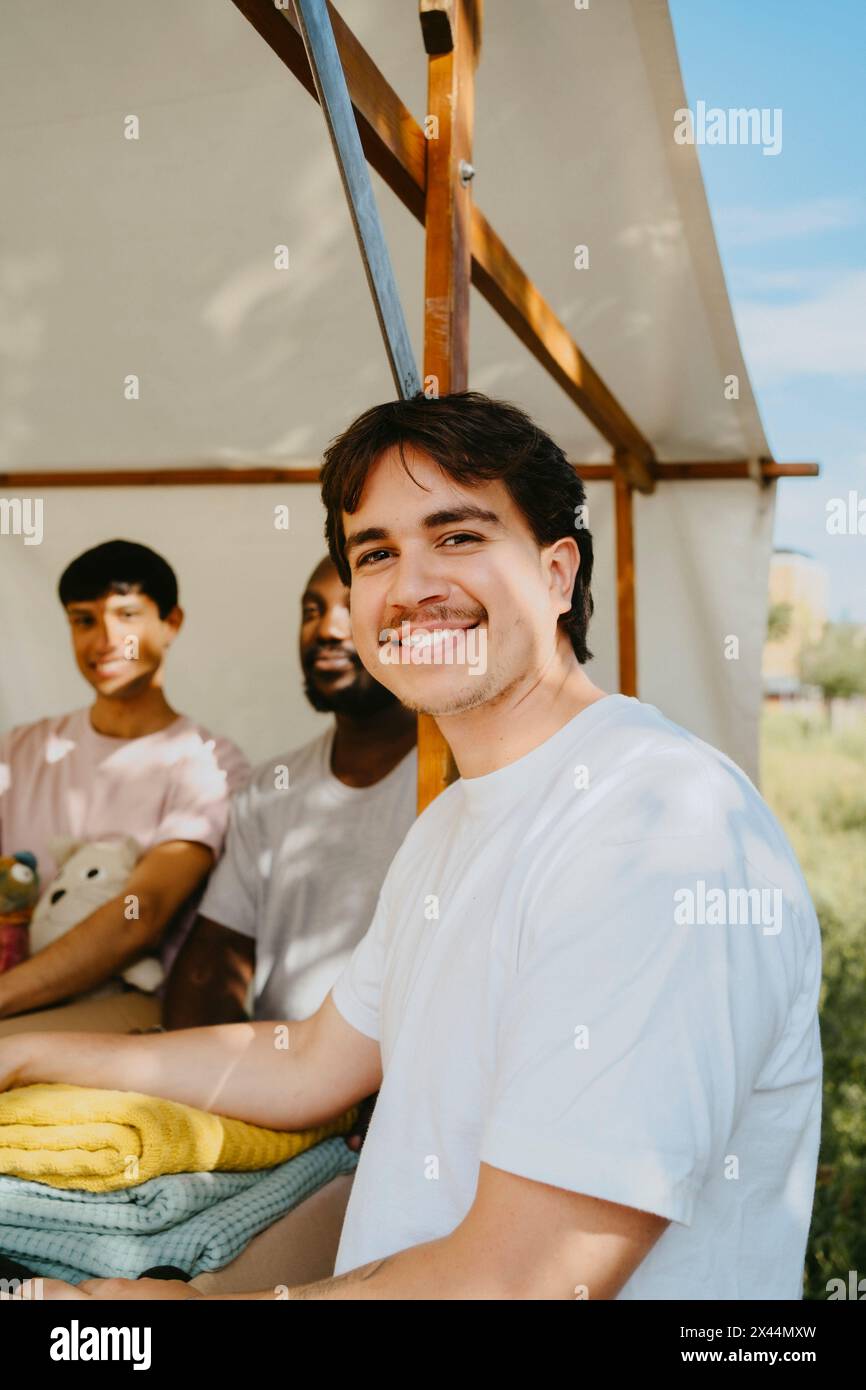 Portrait of smiling male volunteer wearing white t-shirt at community center Stock Photo