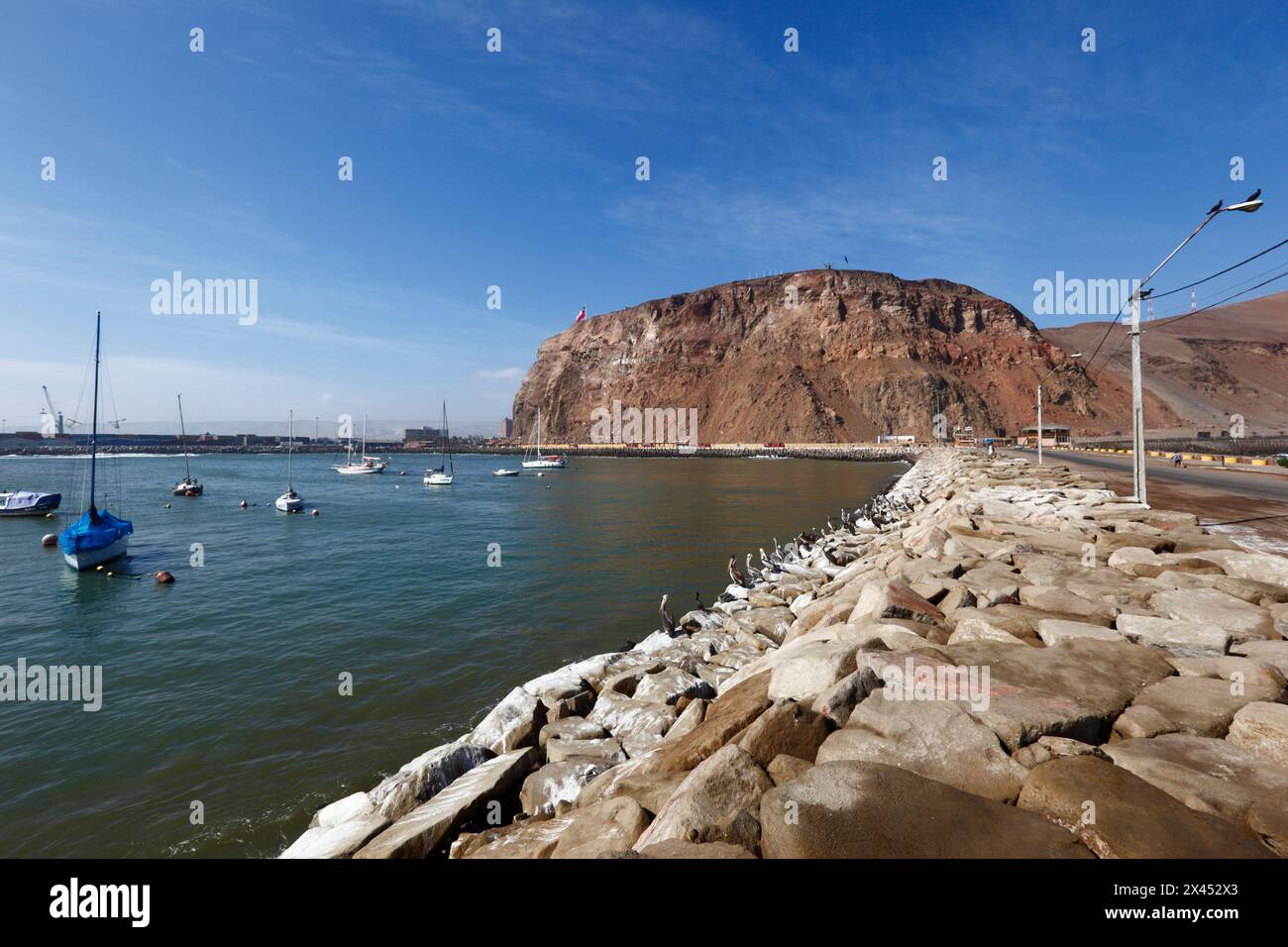 Rock armour revetment preventing coastal erosion next to causeway connecting Alacrán Island to mainland and El Morro headland, Arica, Chile Stock Photo