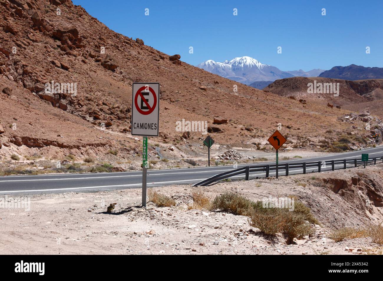 No parking for trucks sign next to Highway 11 near Copaquilla, Nevados de Putre / Taapaca volcano in background, Arica and Parinacota Region, Chile Stock Photo