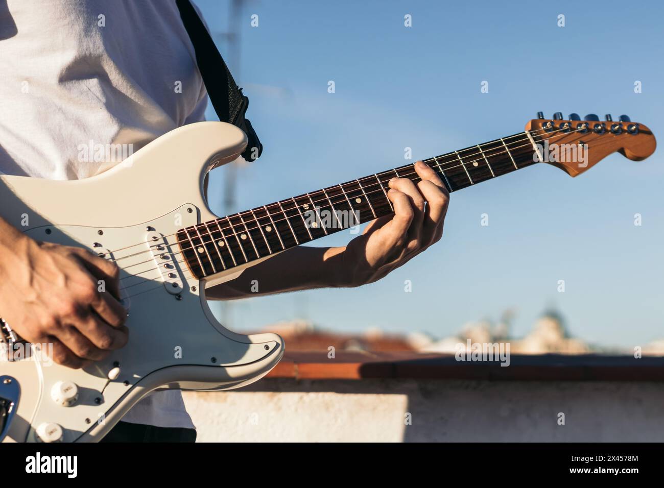 man playing electric guitar on a rooftop Stock Photo