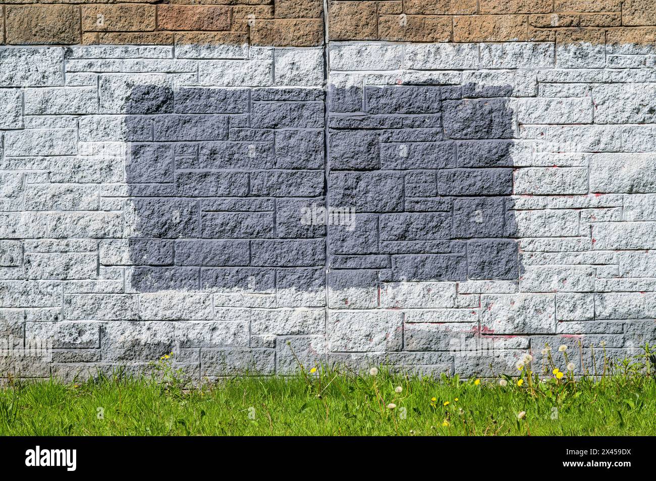 Brick wall painted grey to hide something, UK Stock Photo