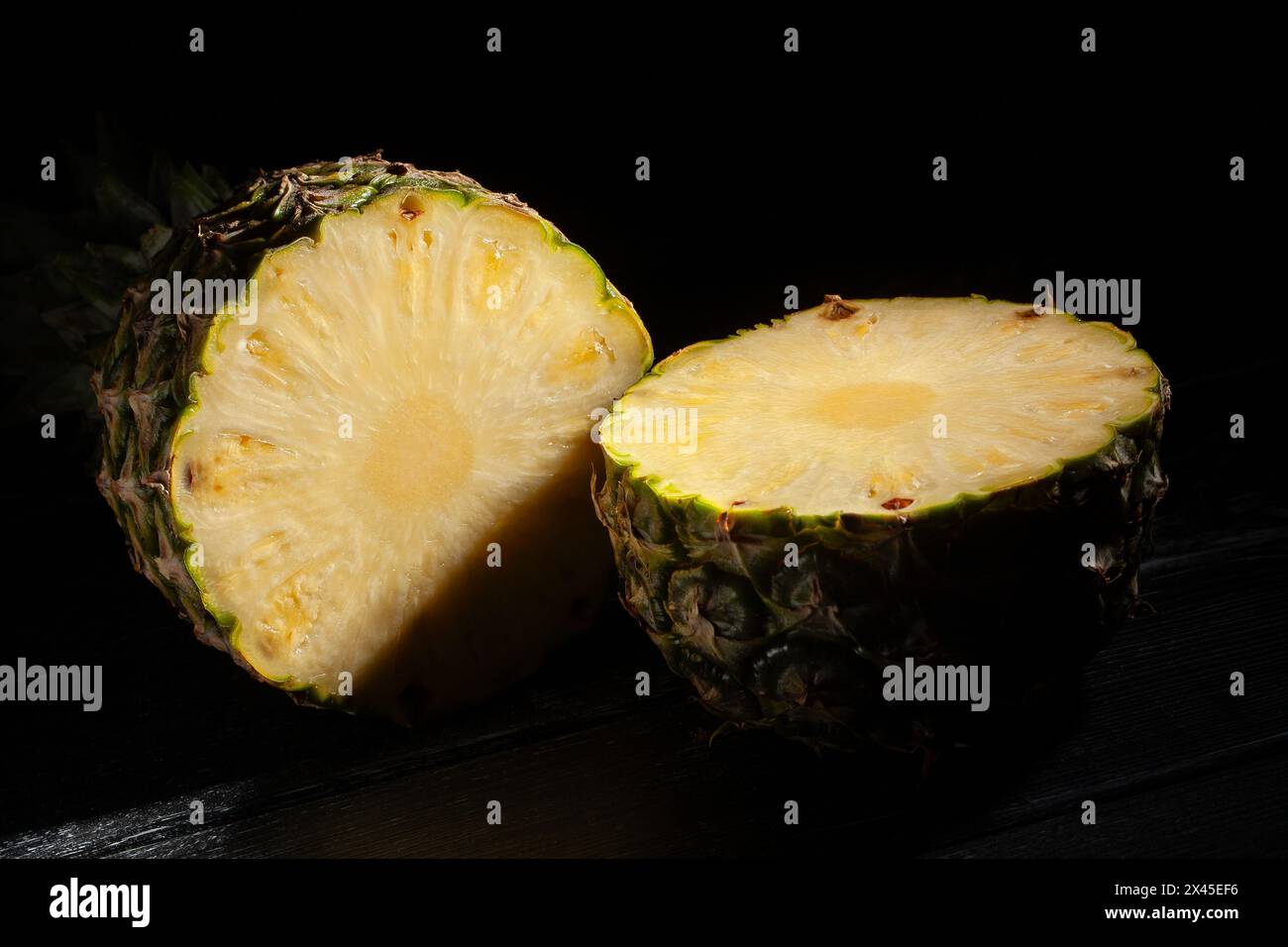 sliced pineapple on black wood background Stock Photo