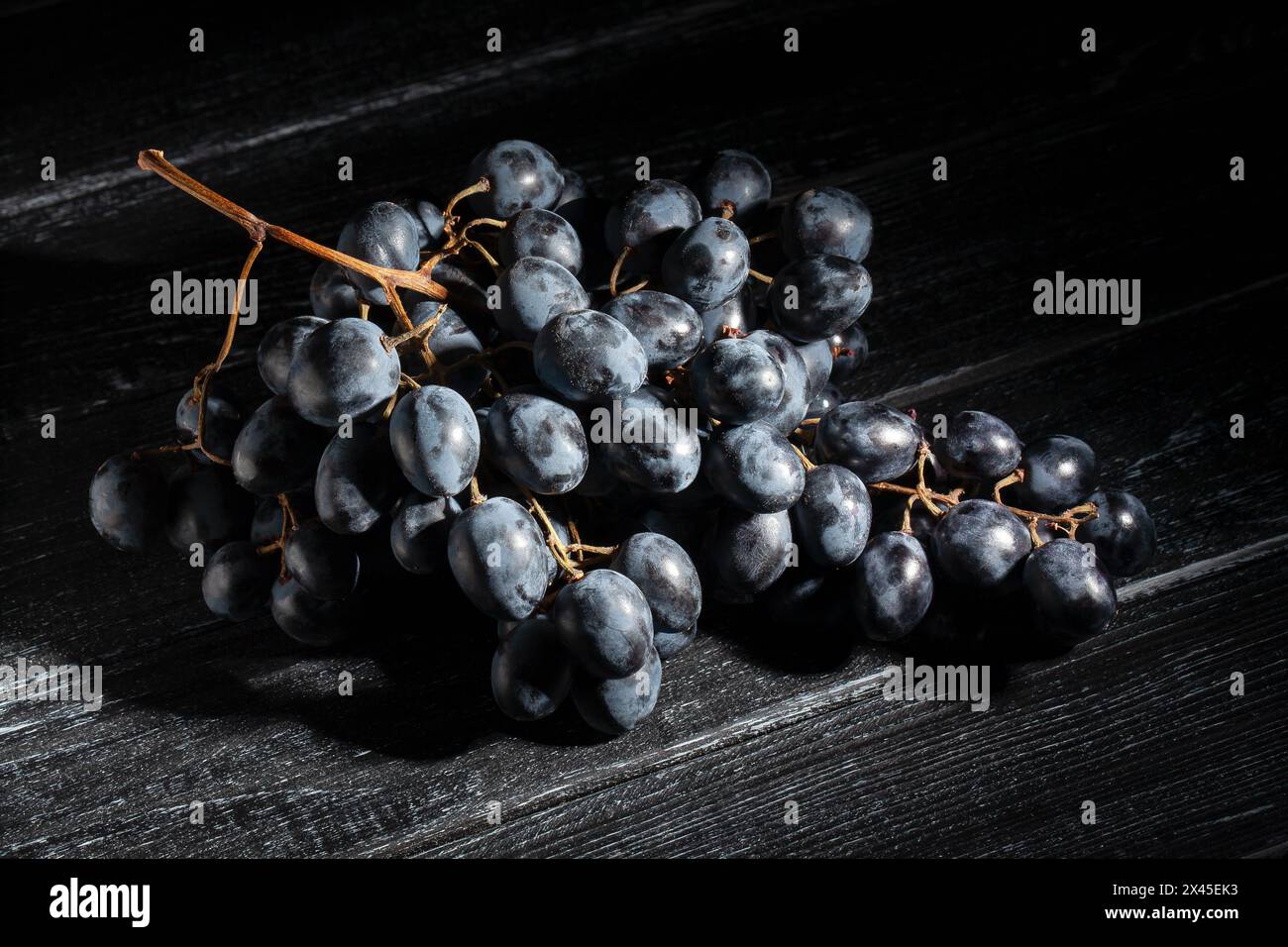 blue grapes on black wood background Stock Photo