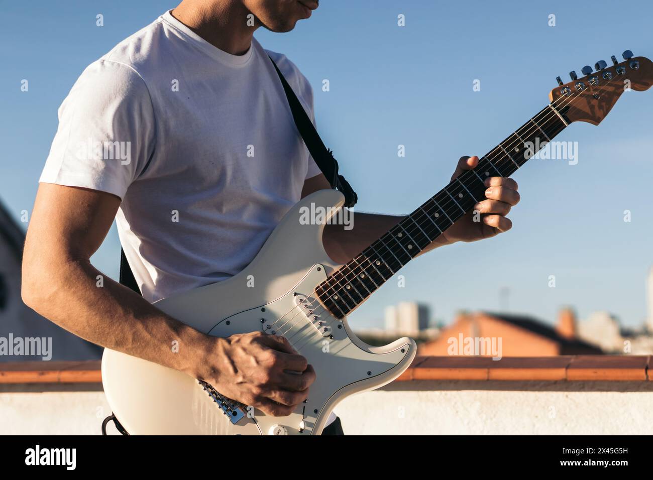 man playing electric guitar on a rooftop Stock Photo
