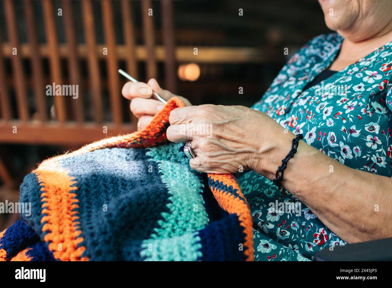 Elderly woman crocheting a blanket. She is concentrating on her task ...