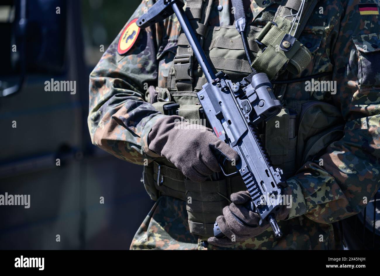 30 April 2024, Saxony, Weißkeißel: A Bundeswehr soldier holds an MP7 submachine gun during the 'National Guardian 2024' exercise as part of the 'Quadriga' series of Bundeswehr exercises at the Oberlausitz military training area. During the Bundeswehr exercise 'National Guardian', homeland security forces throughout Germany are practising their core mission of protecting and securing infrastructure that is vital to the country's defense. Reserve service members from the Homeland Security Company from Saxony, Saxony-Anhalt and Thuringia are taking part in today's exercise. Photo: Robert Michael/ Stock Photo