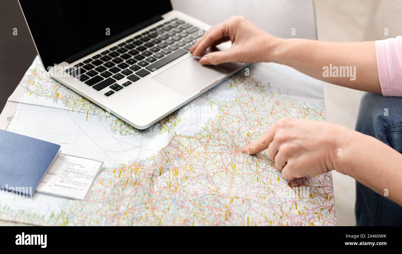Unrecognizable Woman Using Laptop Computer on Map Stock Photo